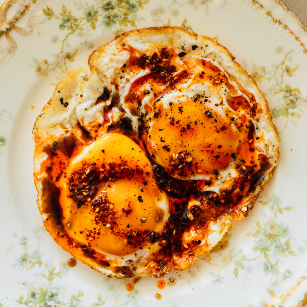 Close-up of a fried egg on toast with a floral patterned plate